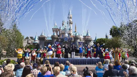 Handout via Getty Images Characters and audience celebrate outside of Disneyland Park