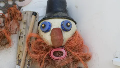 Plastic waste face with hat and beard