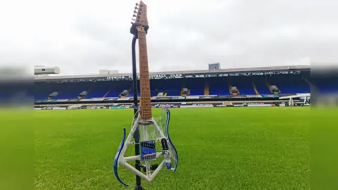 Sheryl Rush guitar at a football ground