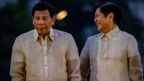 Getty Images Philippine President Rodrigo Duterte and President-elect Ferdinand "Bongbong" Marcos Jr. poses for pictures during the oathtaking of Sara Duterte as the next Vice President on June 19, 2022 in Davao, Philippines.