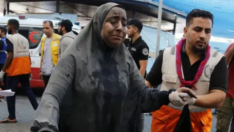 Getty Images Injured woman brought in to Al-Shifa hospital, 27 October 2023