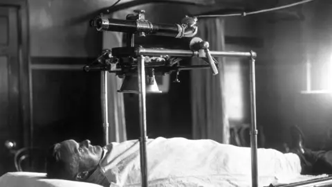 Topical Press Agency A person demonstrating X-Ray apparatus in the 1930s