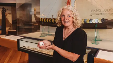 MNH Kath Giles holding one of the Viking coins