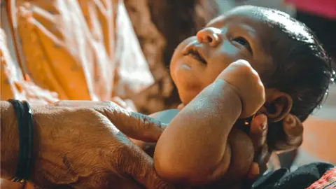 Getty Images An Indian grandmother holds a new-born boy