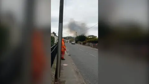 emergency services worker with smoke in the distance
