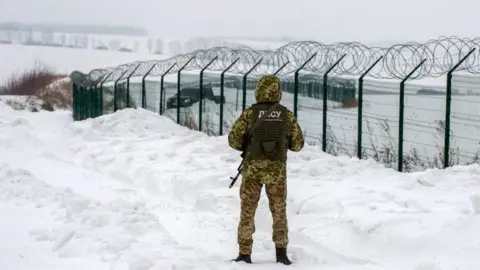 AFP via Getty Images Ukrainian frontier guard is stationed along the border with Russia, some 40 km from the second largest Ukrainian city of Kharkiv