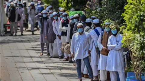 Getty Images People who took part in a Tablighi Jamaat function earlier this month walk to board buses taking them to a quarantine facility amid concerns of infection, on day 7 of the 21 day nationwide lockdown imposed by PM Narendra Modi to check the spread of coronavirus, at Nizamuddin West on March 31, 2020 in New Delhi, India.