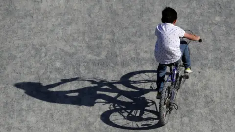 Reuters A boy rides a bicycle in a park in Brussels as Belgium remains under lockdown