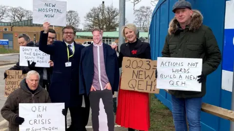 Jill Bennett/BBC Cardboard cut-out of Lord Markham with protesters