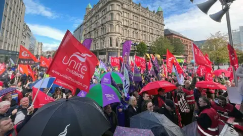 Claudia Savage/PA Media Workers staging a demonstration outside Belfast City Hall