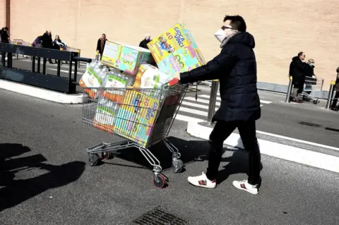 Getty Images A man with a shopping trolley piled high with food