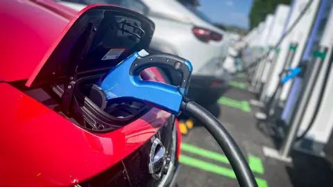 Getty Images Red car being charged