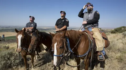 Getty Images The Madison County Sheriff's Mounted Patrol watch the eclipse atop horses on Menan Butte on August 21, 2017 in Menan, Idaho.