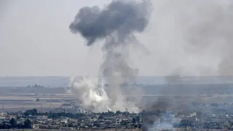 Getty Images Smoke rises from the Syrian town of Ras al-Ain, from the Turkish side of the border