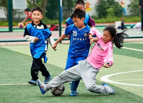 Shi Jiamin/VCG via Getty Images Primary school students play football at a fitness centre on April 27, 2024 in Jiaxing, Zhejiang Province of China.