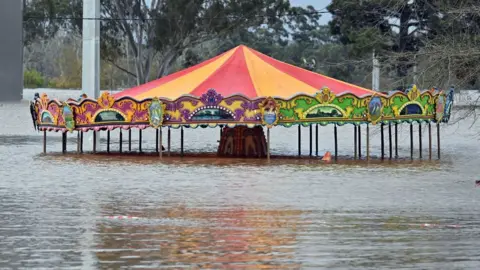 An amusement ride is seen inundated by floodwaters in Camden in South Western Sydney.