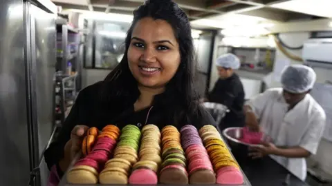 Getty Images In this photograph taken on February 20, 2015, Indian pastry chef Pooja Dhingra poses holding a tray of macaroons at the Le15 - Patisserie bakery in Mumbai.