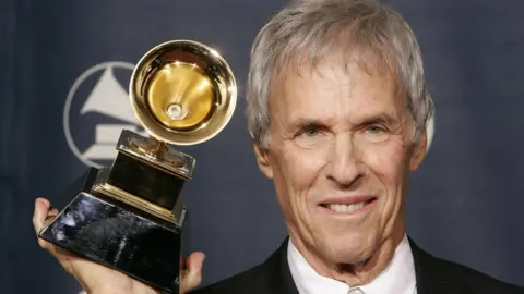 Reuters Composer Burt Bacharach poses with the Grammy award he won for best pop instrumental album for 'At This Time' at the 48th annual Grammy Awards in Los Angeles February 8, 2006