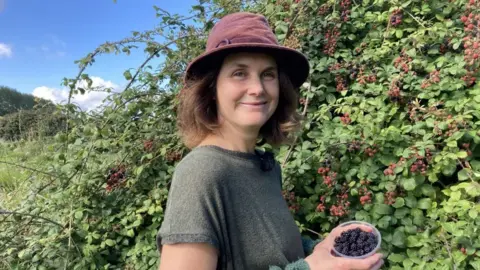 BBC Sarah-Jane Cobley standing next to a bush