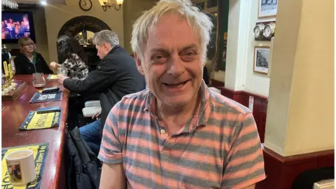 BBC Owner and landlord, Jonty Newbery sat on a bar stool smiling