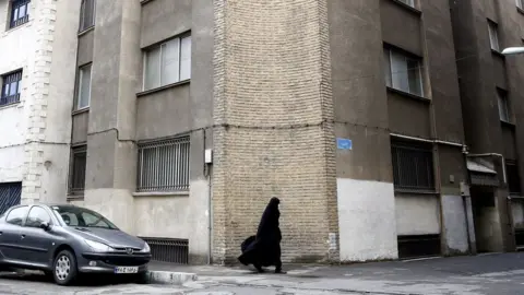 EPA A woman walks past the French Institute for Research in Tehran, Iran (5 January 2023)