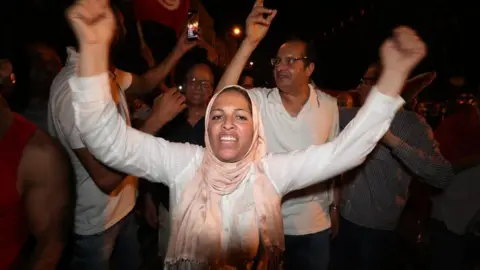 EPA Supporters of president Kais Saied celebrate after an exit poll indicates voters backed new constitution in Tunis, Tunisia, 25 July 2022