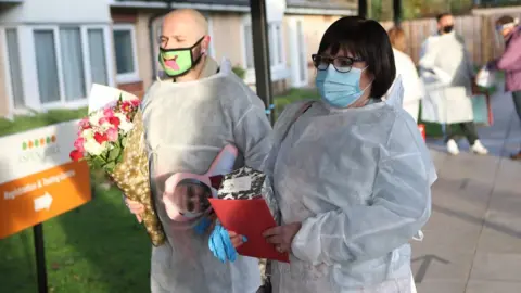 PA Media Mary Orme and her son Michael McKimm arrive for a Christmas Day visit with their mother and grandmother, Rose McKimm, at Aspen Hill Village care home in Hunslet, Leeds.