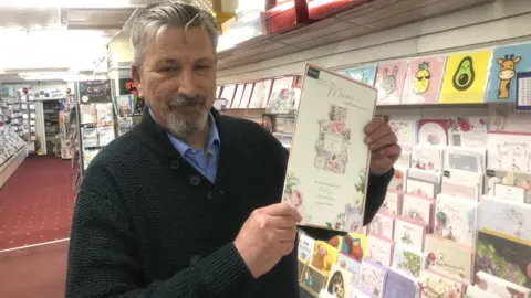 John Devine/BBC Shopkeeper Nigel Lambert in his card shop in March, Cambridgeshire