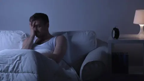 Getty Images Man waking up in bed