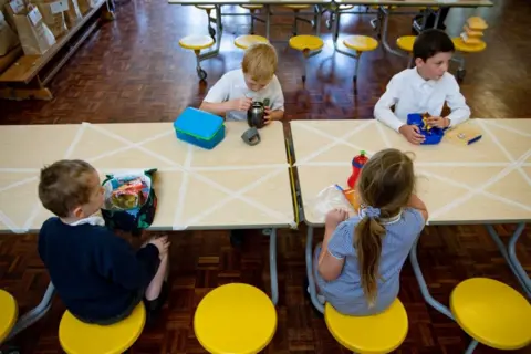 PA Media May 18 2020. Children of essential workers eat lunch in segregated positions at Kempsey Primary School in Worcester. Nursery and primary pupils could return to classes from June 1 following the announcement of plans for a phased reopening of schools.