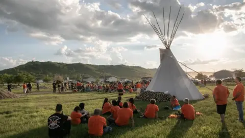 Getty Images First Nations community members gather during a vigil in the recently discovered unmarked graveyard in a former catholic Indian residential school in Cowessess first nation community of Marieval, in Saskatchewan, Canada