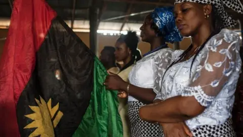 AFP A woman holds a Biafran flag during a service at the St. Martin Catholic of Tours Church on May 28, 2017 in the Aba-South district in Aba.