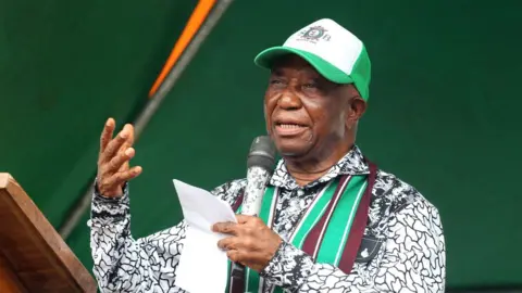 EPA Mr Boakai addresses supporters during a campaign rally, holding a microphone