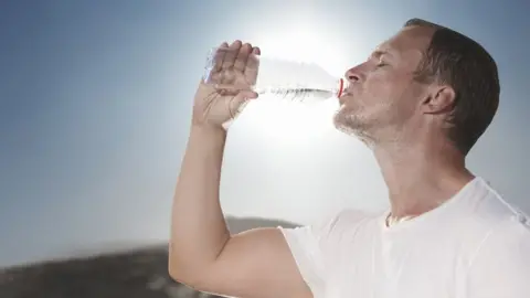 Getty/mrPliskin Hot sunny day drinking water from a bottle - stock photo