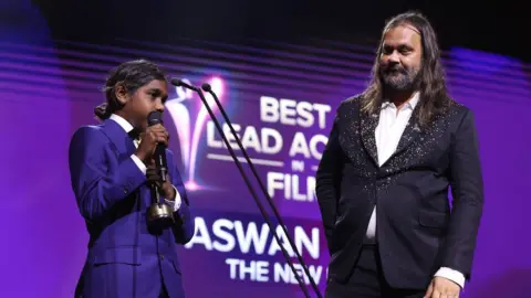 Getty Images Aswan Reid, on stage with Warwick Thornton, accepting his AACTA prize