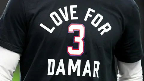 An NFL player wears a T-shirt with 'Love for Damar 3' on it prior to the Las Vegas Raiders-Kansas City Chiefs game to honour Buffalo Bills player Damar Hamlin