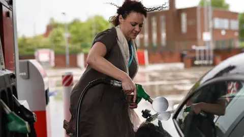 Getty Images Woman fills car with fuel