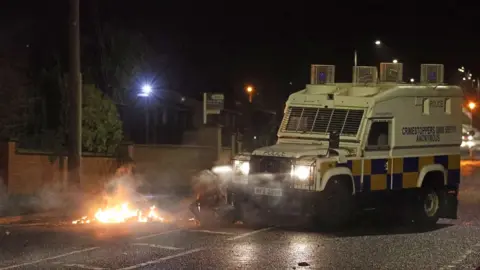 Liam McBurney/Pa Wire Police moving a bin which was set alight on North Road in Carrickfergus on Sunday night