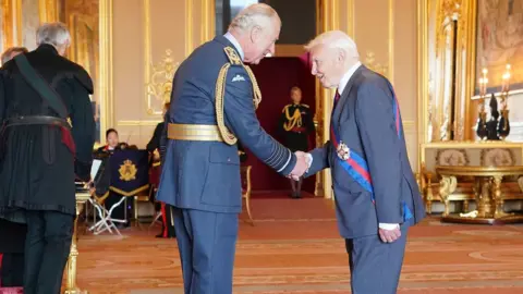 PA Media Sir David being honoured by the Prince of Wales