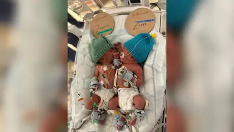 Family photo Newly born Zayne and Zion in hospital cot