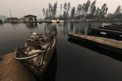 Getty Images A burnt boat sits at a marina on Whiskeytown Lake