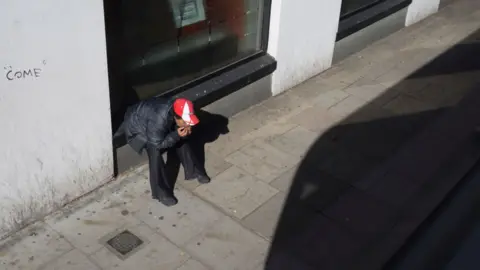 Getty Images A person wearing an England cap looks down at the ground in Camberwell