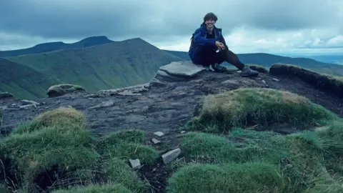 Myrddyn Phillips Myrddyn Phillips sat on the summit of Fan y Big