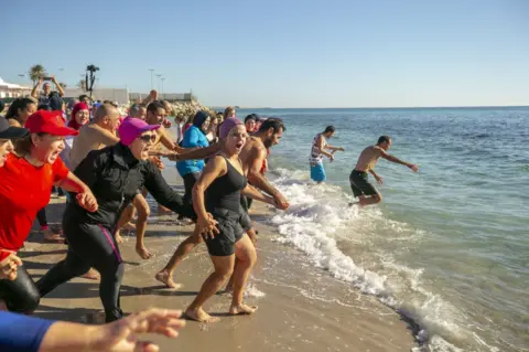 Getty Images People attend swimming event on the first day of new year as daily life continues in Nabil, Tunisia on January 01, 2023