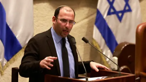 AFP via Getty Images Israeli Parliament member Simcha Rotman speaks during a parliament meeting in Jerusalem in July