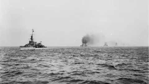 Alamy IWM - THE SURRENDER OF THE GERMAN HIGH SEAS FLEET, NOVEMBER 1918: Royal Navy light cruiser HMS Cardiff leading the German battle cruisers into the Firth of Forth.