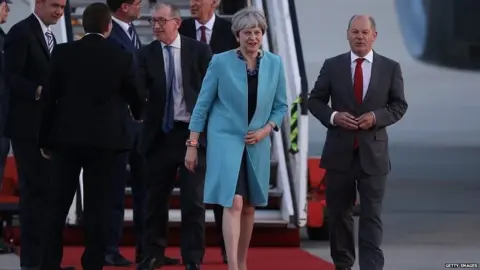 Getty Images Theresa May greeted by Olaf Scholz, the mayor of Hamburg, as she arrives in the city for the G20 summit