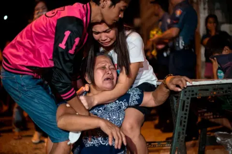 Getty Images This photo taken on February 18, 2017 shows the mourning mother of an alleged drug dealer after he was shot by unidentified assailants in Manila.