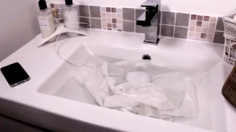 Dolfi Dolfi gadget in sink with shirt and some water