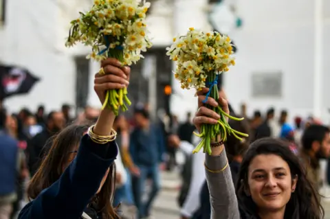 Getty Images Anti-racism protesters hold up flowers in Tunis, Tunisia - Saturday 25 February 2023